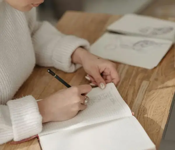 Femme qui écrit dans un cahier, illustrant le tarif d’une séance de psychothérapie à Reims