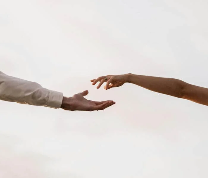 Deux mains qui se rejoignent, illustrant l’aide financière d’une mutuelle pour une séance de psychopraticienne